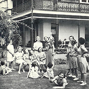 In the garden at Barnardo House.The white Cockatoo on the senior girl's shoulder is the pet of the home.